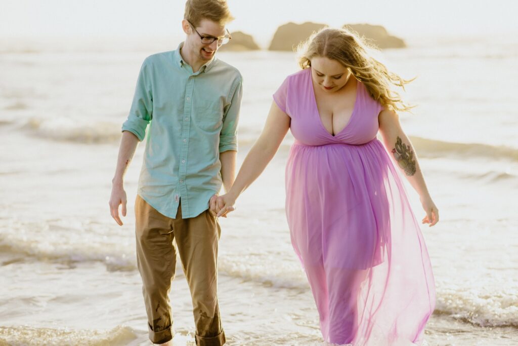 Engaged couple walks on Moonstone Beach during portrait session