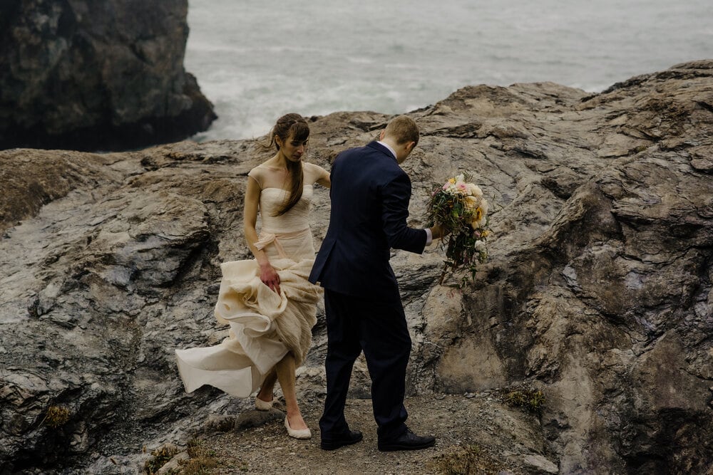 Bride and groom walk along craggy bluffs near Wedding Rock in Sue-Meg State Park