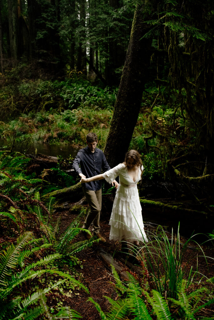 Couple walks through the redwoods during an engagement session in Northern California