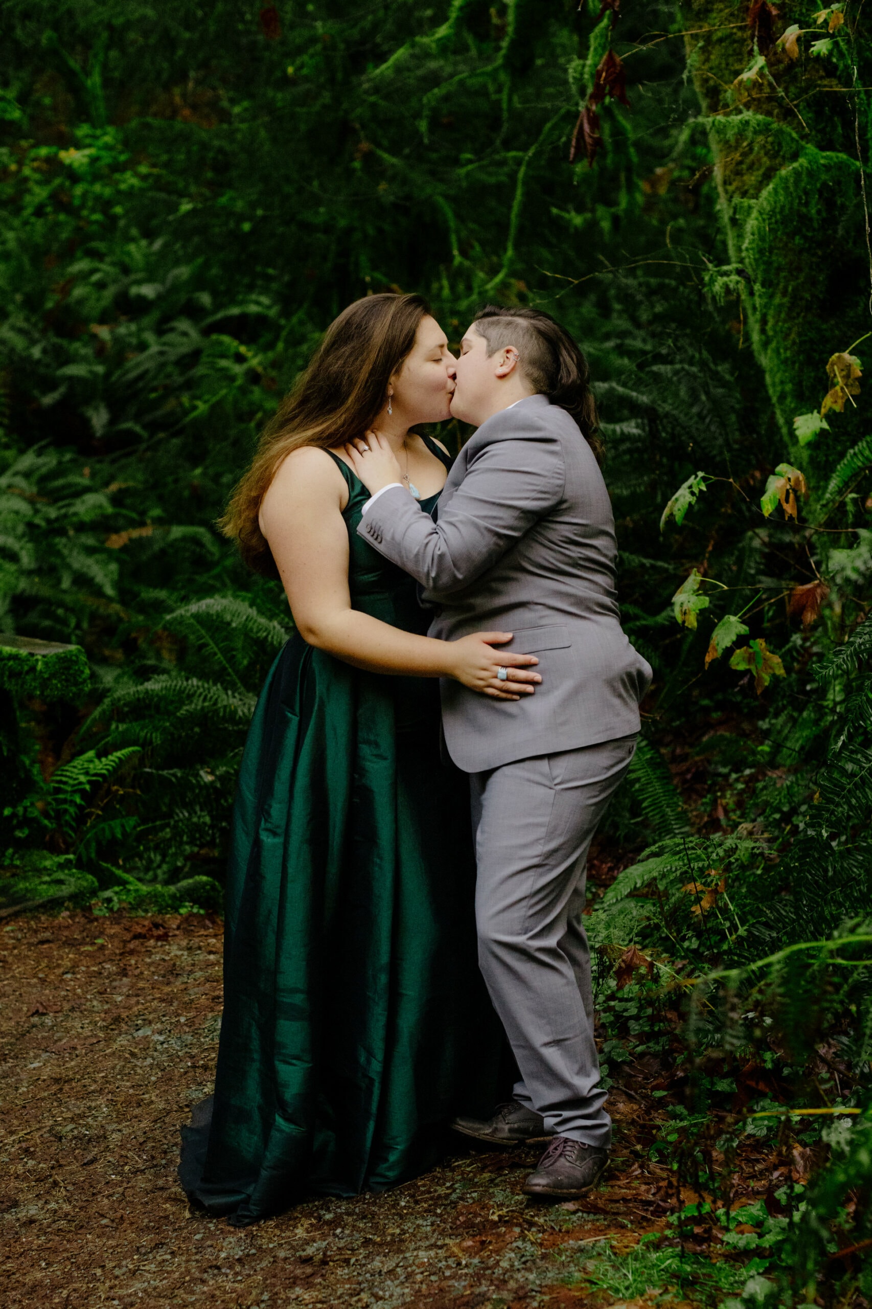 Brides kiss during a forest engagement session in Trinidad State Park in Northern California