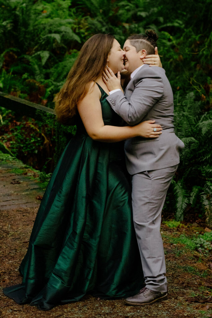 Two brides kissduring forest engagement session in Northern California