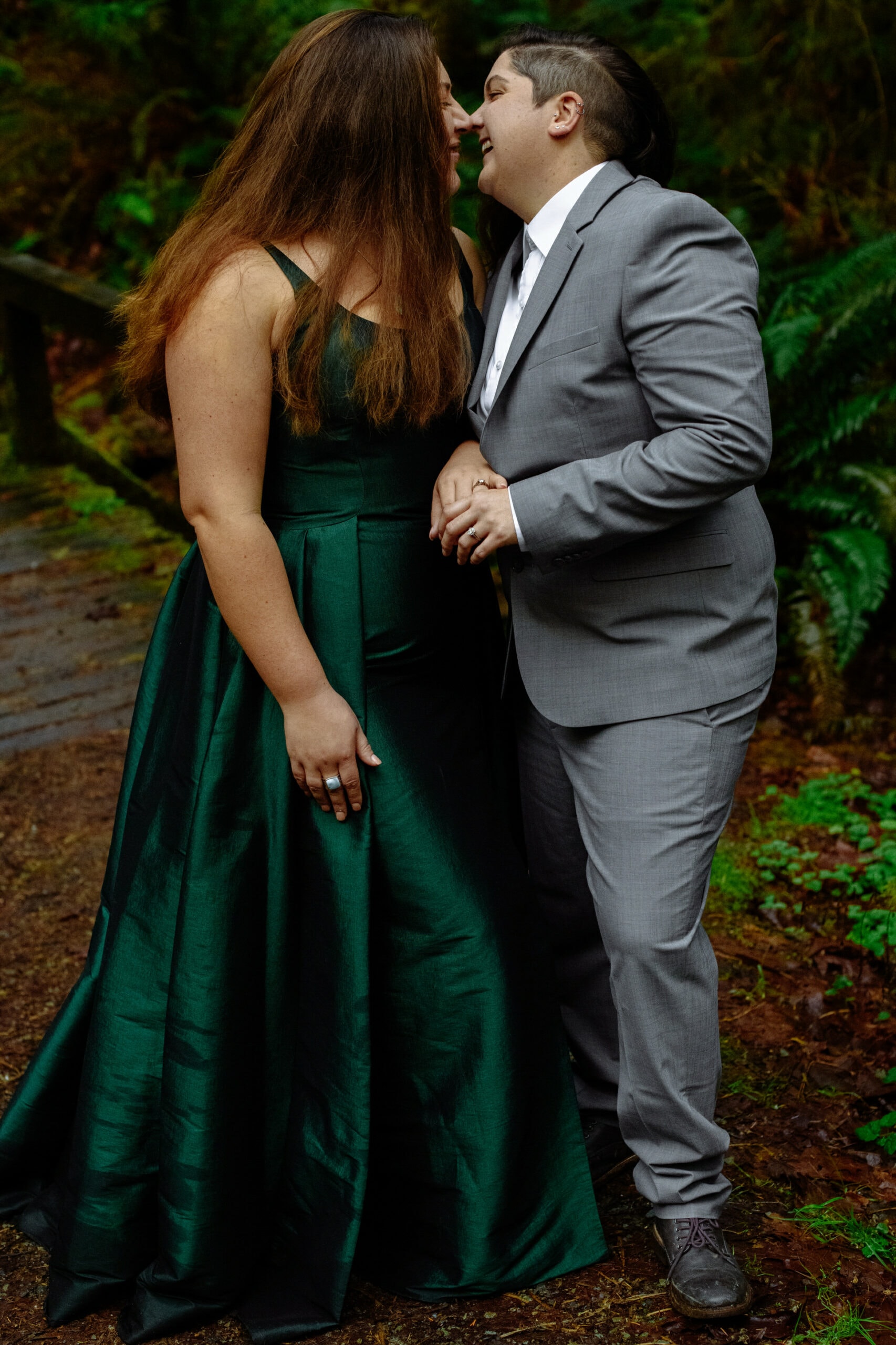 Couple in grey suit and green ball gown during forest engagement session in Northern California