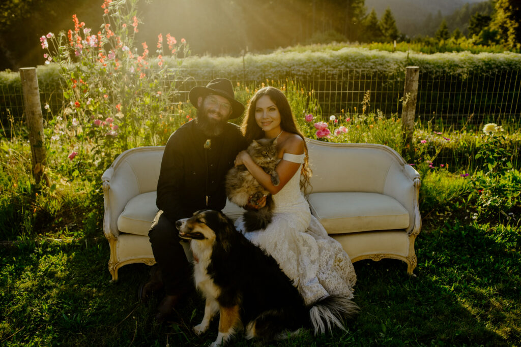 Bride and groom sit with pets at flower farm wedding in Northern California