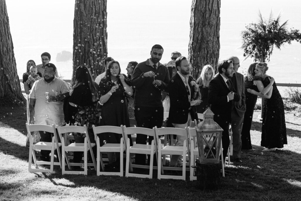 Guests blow bubbles on the lawn after a wedding ceremony at the Lost Whale Inn
