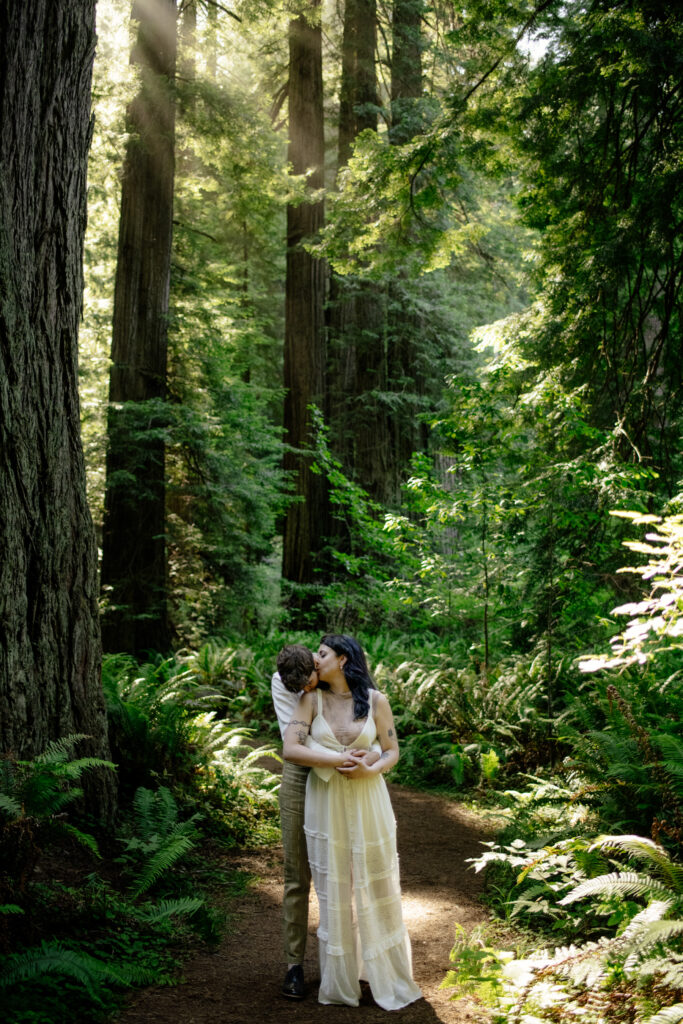 Two brides embrace in Prairie Creek Redwoods in the Redwood National Forest in Northern California