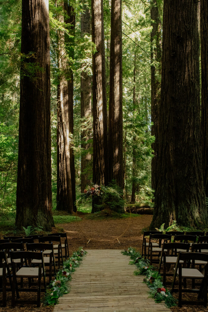 Ceremony location in the Northern California redwoods featuring floral moon door.