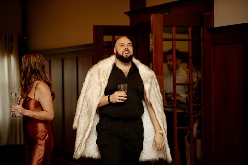Wedding guest with white faux fur coat and black button down at Scotia Lodge in Northern California